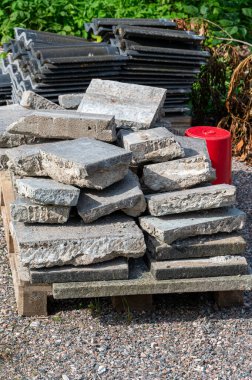 Tahta Euro paletleri üzerindeki taşlar ve çatı fayansları Kumla İsveç 9 Eylül 2023