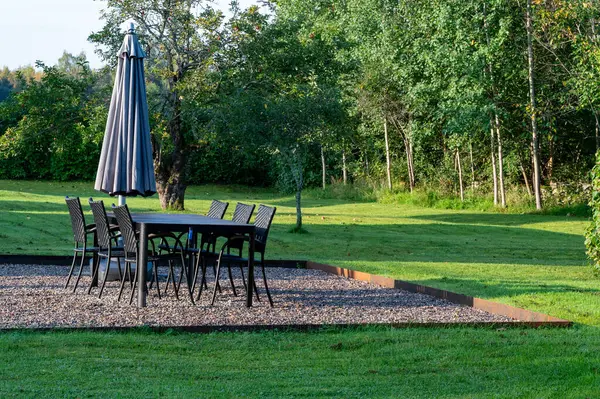 Garden furniture with parasol on gravel in private garden Kumla Sweden September 27 2023