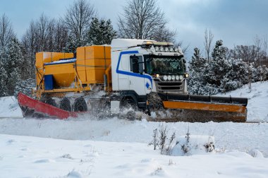 Kamyon kar temizliyor ve Hallsberg yoluna tuz döküyor. 29 Kasım 2023