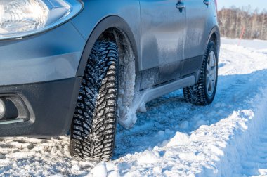 Kar üzerinde duran arabanın çivili lastiklerini kapatın. Kumla İsveç 29 Kasım 2023