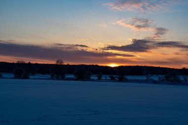 İsveç Hallsberg 'de 4 Aralık 2023' te karlı tarlalarda gün doğumu