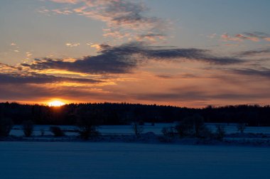 İsveç Hallsberg 'de 4 Aralık 2023' te karlı tarlalarda gün doğumu