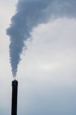 Duman sütunu olan yüksek baca gri gökyüzüne karşı Kumla İsveç 6 Aralık 2023