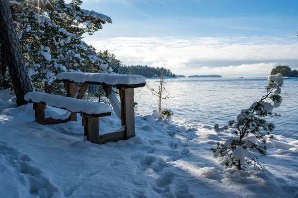 Bench and small table overlooking lake Vattern Motala Sweden February 9 2024