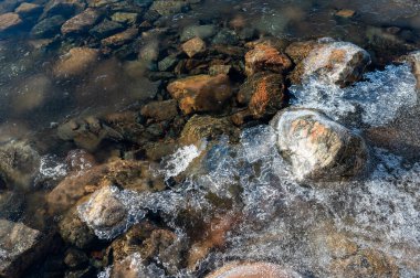 Göl taşlı, berrak su ve buzlu Motala İsveç 9 Şubat 2024