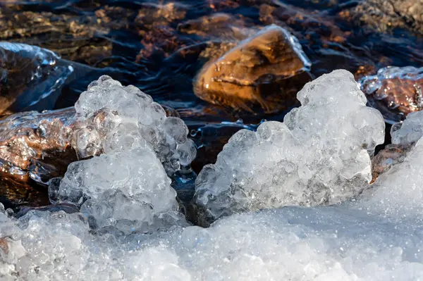 Closeup on natural art of ice and stones in lake Motala Sweden February 9 2024