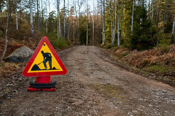 Road work ahead sign on dirt road in forest Motala Sweden April 26 2024