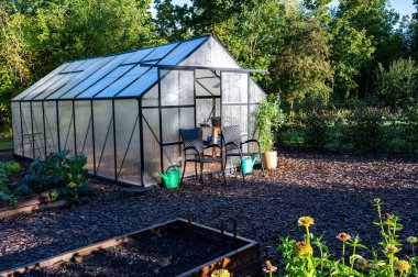 Morning sunshine on greenhouse in vegetable garden Kumla Sweden September 12 2024 clipart