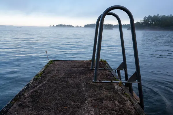 stock image Bathing jetty made of concrete and metal ladder Vastanvik Motala Sweden September 20 2024