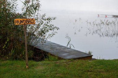 Sign in Swedish meaning Dog bath near jetty in water Motala Sweden October 4 2024 clipart