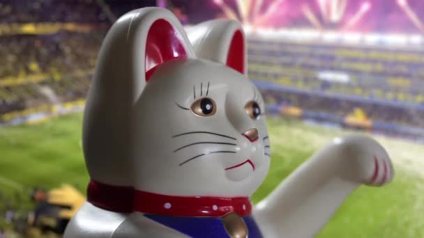 Maneki Neko Cat Beckoning Cat Contra Estadio Fútbol Borroso Primer — Vídeo de stock