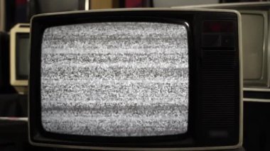 Old Television Turning On Chroma Key Green Screen Among Many Old Vintage Televisions. Close Up.