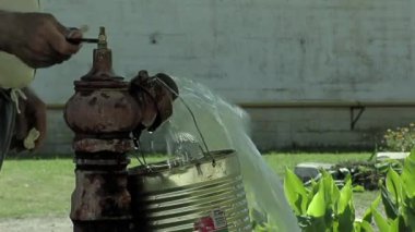 Gardener Opening an Old Broken Hand Water Pump using a Wrench in the Yard of a Prison in Argentina. Close Up 
