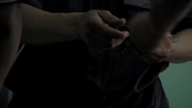 Penitentiary Officer Giving Identification Cards to Inmates on a Hallway in an Argentine Prison. Close Up.  