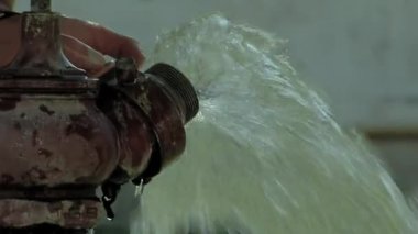 Inmate Drinking Water from an Old Hand Water Pump in the Yard of an Argentine Prison. Close Up. 