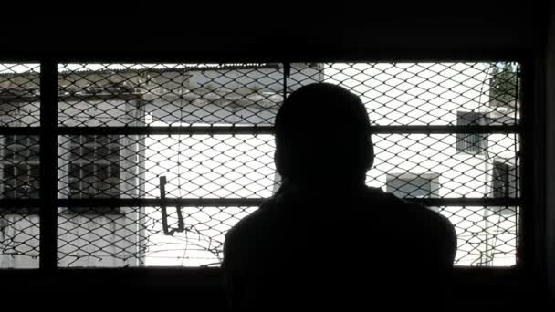 Σιλουέτα Κρατούμενου Που Κοιτάζει Μέσα Από Κάγκελα Παραθύρων Μέσα Κελί — Αρχείο Βίντεο