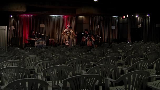 Νέοι Μουσικοί Στη Σκηνή Ένα Άδειο Αμφιθέατρο Πλαστικές Καρέκλες Σειρές — Αρχείο Βίντεο
