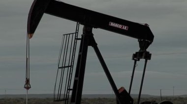 A Pump Jack operating at an Oil Well in the Neuquen Basin in northern Patagonia, Argentina.  