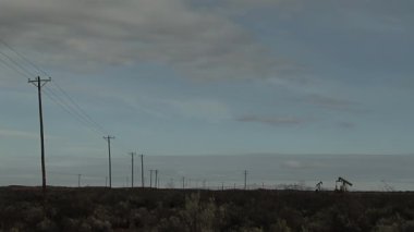 Petrol Çavdarları, Arjantin 'in Neuquen kentindeki Bir Elektrik Hattı Yakınındaki Kuru Patagonya Peyzajında Çalışıyor