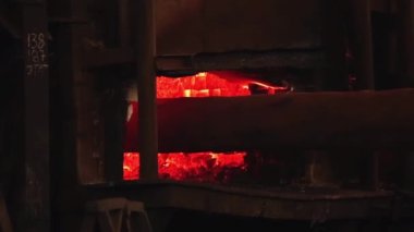 Metal döküm çelik fabrikasında, çelik yuvarlak bar ocakta ısıtılıyor. Yakın çekim. 4K Çözünürlüğü.