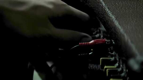 人工将仪器电缆插入吉他放大镜中 特写镜头 — 图库视频影像