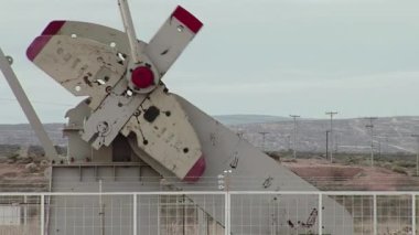 Kuzey Patagonya, Arjantin 'de bir petrol sahasında çalışırken Pumpjack Counterweight Turning. Yakın çekim. 4K Çözünürlüğü.