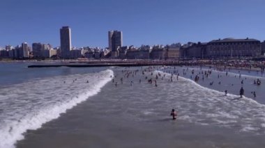 Yazın kalabalık halk plajı, Arjantin 'in Mar del Plata şehrinde güneş ve deniz suyunun tadını çıkaran insanlar. 4K Çözünürlüğü.