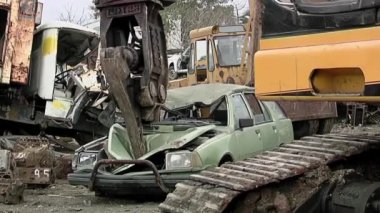 Hurdalıkta hurda bir arabayı kaldıran bir turna. 4K Çözünürlüğü.