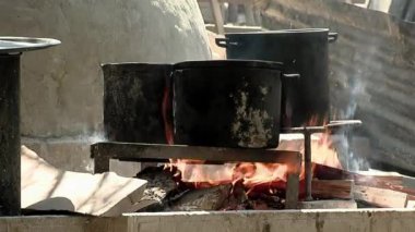 Açık ateşte Yanmış Paslanmaz Çelik Tencerelerle Yemek Hazırlayan Kadın 