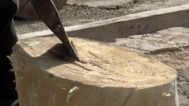 Man Cutting a Trunk while making a Bombo Leguero, the Argentine Drum made with Wood and Animal Leather, used in Local Folklore Music. Kapat.. 