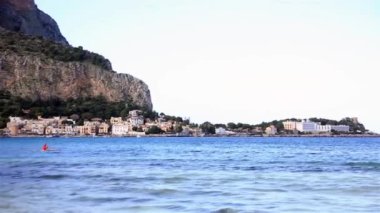 Sicilya 'da Spiaggia di Mondello' da Gallo Dağı 'nın arkasında sallanan kırmızı şamandıralar.