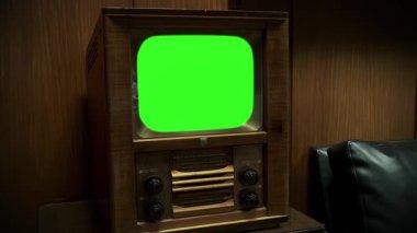 1940-50 'lerin antika tahta çerçeveli televizyonu ve Karanlık Oda' da yeşil krom anahtar ekranı var. Yakınlaştır. 4K Çözünürlüğü.