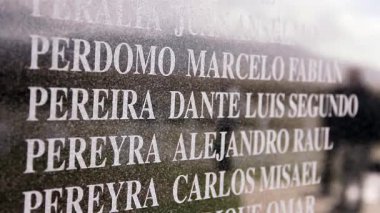 Falkland Adaları 'ndaki Falkland Savaşı' ndan kalma Arjantinli askerlerin isimleriyle dolu bir duvar. 4K Çözünürlüğü.