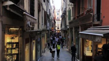İtalya 'nın Venedik şehrinde Dar bir sokakta yürüyen turistler. 