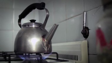 Rustic Kitchen 'da eski bir çaydanlık kaynayan suyu eski bir fırında. 4K Çözünürlüğü.