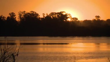 Arjantin 'in La Pampa ilindeki Santa Rosa şehrindeki Don Tomas Gölü' nün Günbatımı Manzarası. Zaman Uygulaması.  