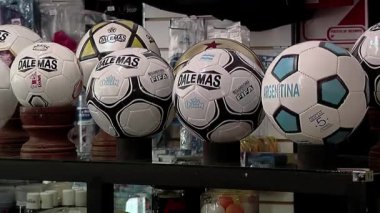 Futbol topu fabrikasının montaj hattında futbol topunu kaldıran bir işçi. Yakın plan. 4K Çözünürlüğü.