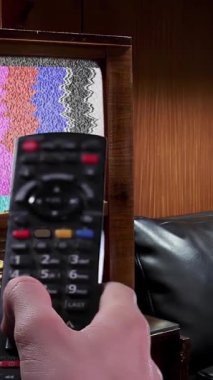 Uzaktan kumanda 1950 'lerin televizyonunu Ahşap Mobilyalı Bir Odada Yeşil Ekran ile Açar - Dikey 4K