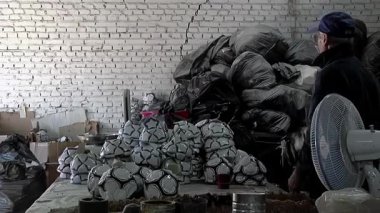 Futbol topu üretimi, futbol topu fabrikasında kalite kontrol kontrolünde deneyimli bir işçi. 4K Çözünürlüğü.