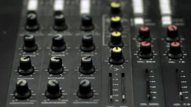 Ses teknisyeni, radyo ve televizyon istasyonundaki konsolun düğmelerini ayarlıyor. Yakın plan. 4K Çözünürlüğü.