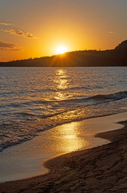 Golden Waves and a Golden Sun on a Great Lakes Beach in Neyes Provincial Park in Ontario clipart