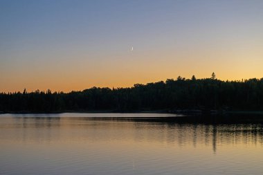 Minnesota 'daki Sınır Suları' ndaki Saganaga Gölü 'nde Günbatımında Hilal Ay.