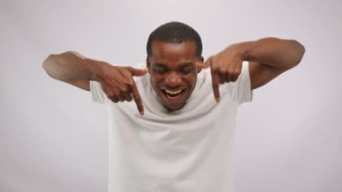 Crazy positive smiling afroamerican guy is showing down by hands and thumbs up. Blogger encourages you to follow the link, subscribe and give likes. Blogging, internet marketing, online job concept.