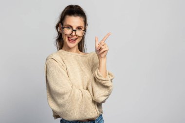 Gözlüklü, genç ve güzel bir bayan. İzole, açık gri arkaplan.