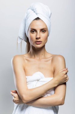 Güzel ve seksi bir kadın kafasına ve vücuduna beyaz havlu takmış. Duygusallık, sağlık ve kaplıca konsepti.