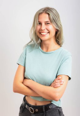 Kollarını kavuşturup kameraya bakan hoş bir genç kadın..