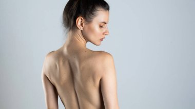 İnce ve güzel bir kadının arkası. Açık gri renkte izole edilmiş.