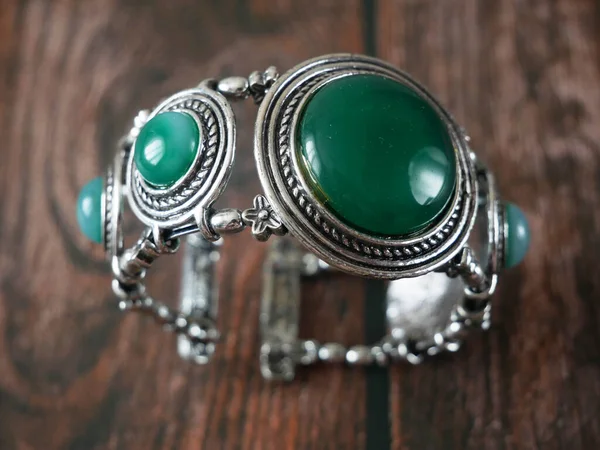 Ahşap Zemin Üzerinde Yeşil Taşlar Olan Klasik Gümüş Bilezik Yakın — Stok fotoğraf