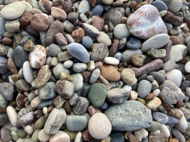 Deniz çakıl taşları arka plan, birçok yuvarlak çakıl taşı dokusu. Çakıl taşı sahili, yakın çekim.