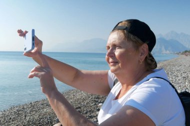 Mavi gökyüzü arka planında kırmızı ve beyaz ay ile Türk ulusal bayrağını sallayan, yakın plan